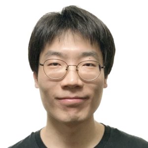 Early career man with glasses and short black hair wearing a black t-shirt